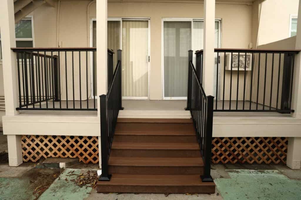 Refinished composite balcony deck with new black railings on a Sacramento apartment building
