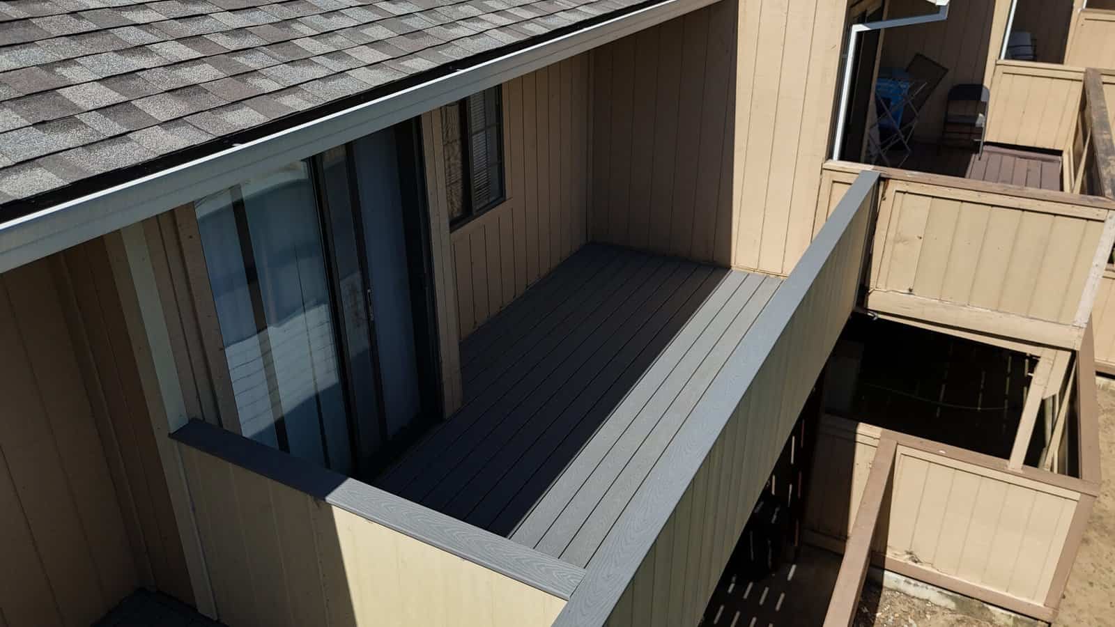 Close-up of light grey capped composite decking boards installed on a rebuilt balcony