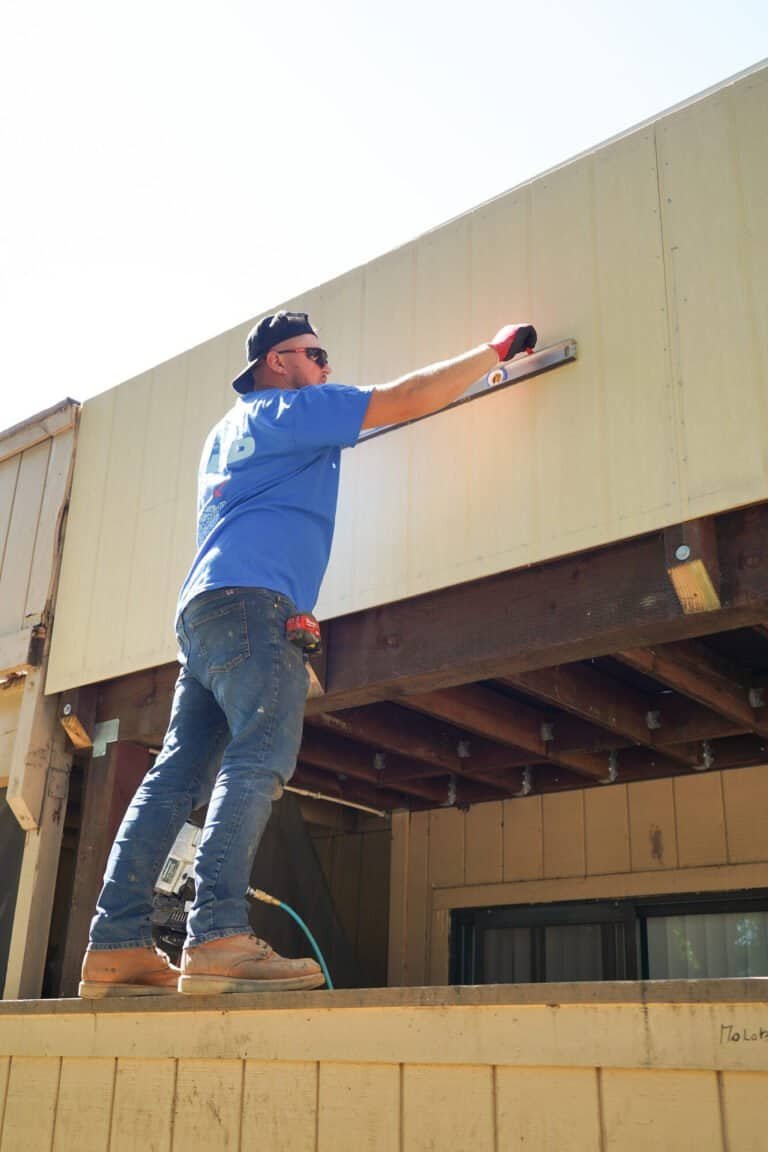 Rebuilt townhome balcony in Antelope with new grey Trex composite decking, capped privacy wall and repainted siding