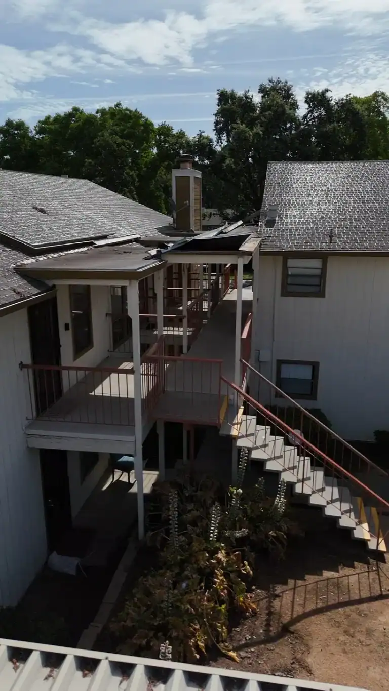 Aerial view of elevated apartment walkways and damaged canopy edges before repair
