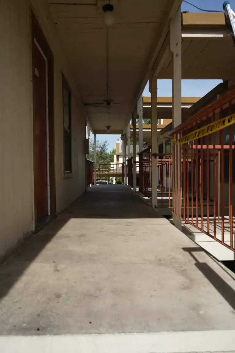Elevated apartment walkway closed with caution tape before waterproofing work