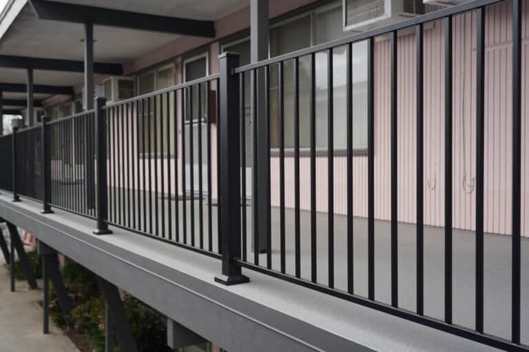 Close-up of new aluminum picket guardrail on a freshly coated apartment walkway