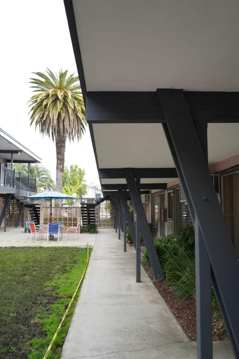 Repainted steel columns and braces supporting a rebuilt apartment walkway