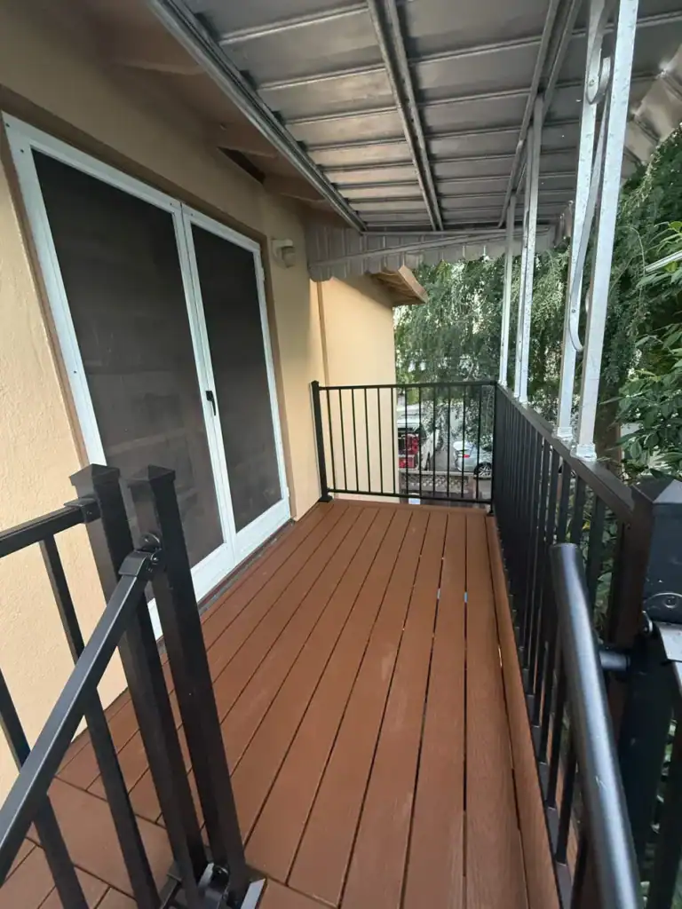 The same balcony finished in Trex composite decking with a new aluminum guardrail and gate