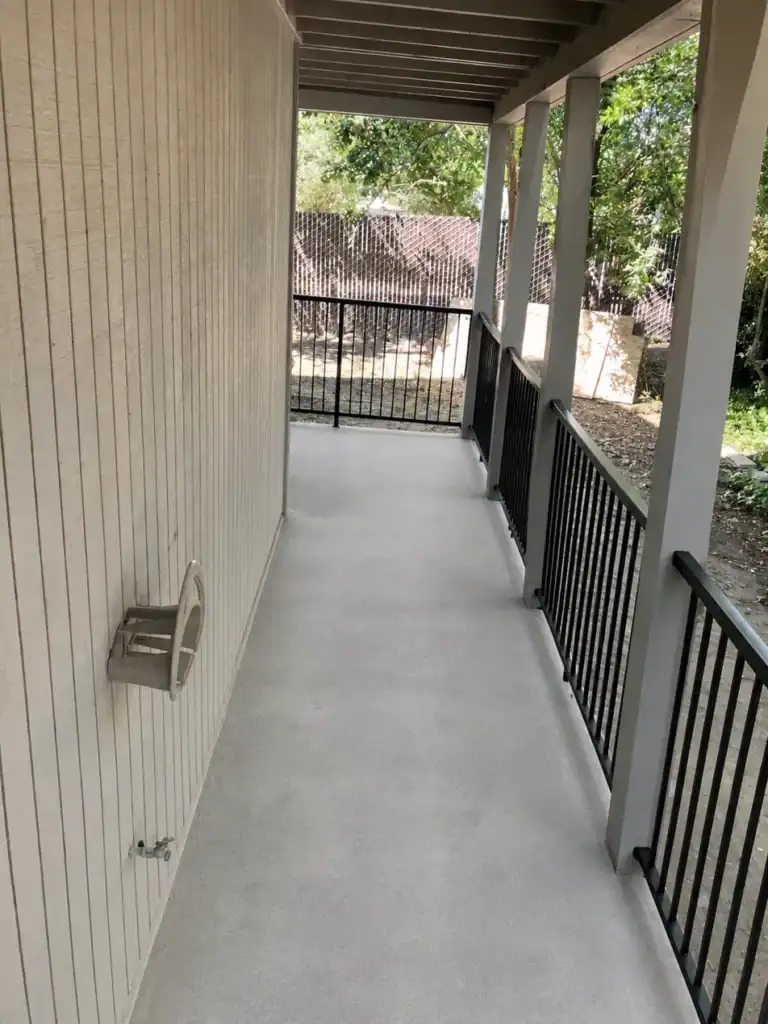 Apartment walkway after structural repair and waterproof coating, with no damage remaining