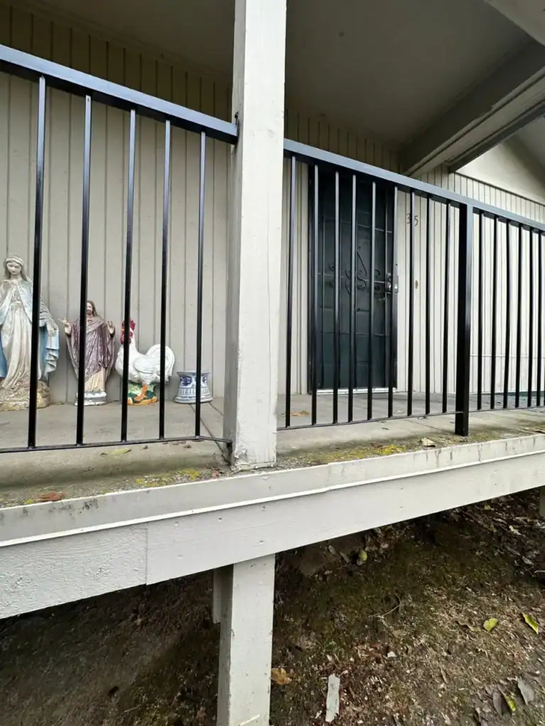 Moss and weathered fascia at the edge of a ground-floor apartment patio before repair