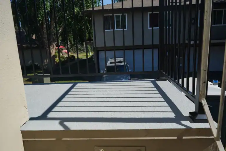 Finished balcony deck and guardrail overlooking the parking court