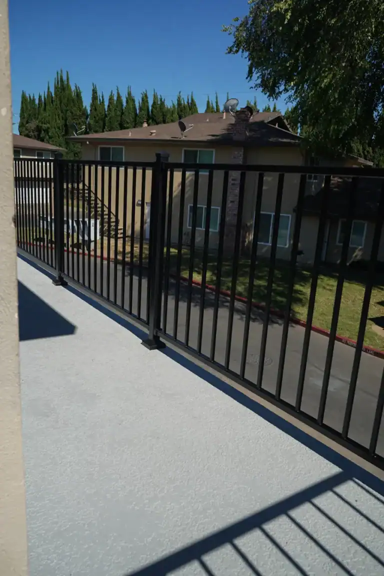 Rebuilt balcony deck with textured non-slip coating and new railing above the garages