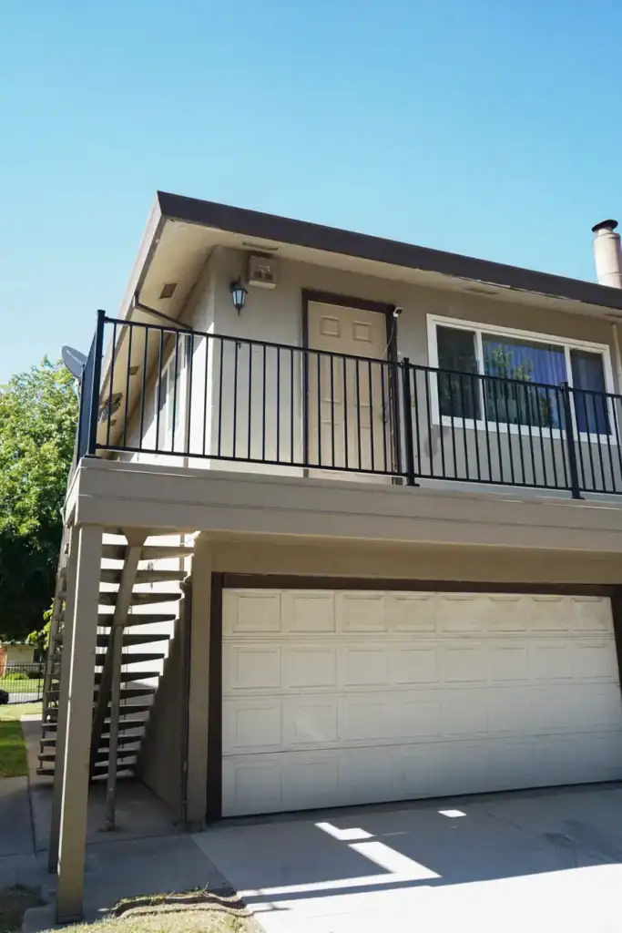 The rebuilt entry balcony with new deck coating, black aluminum guardrail and repainted structure