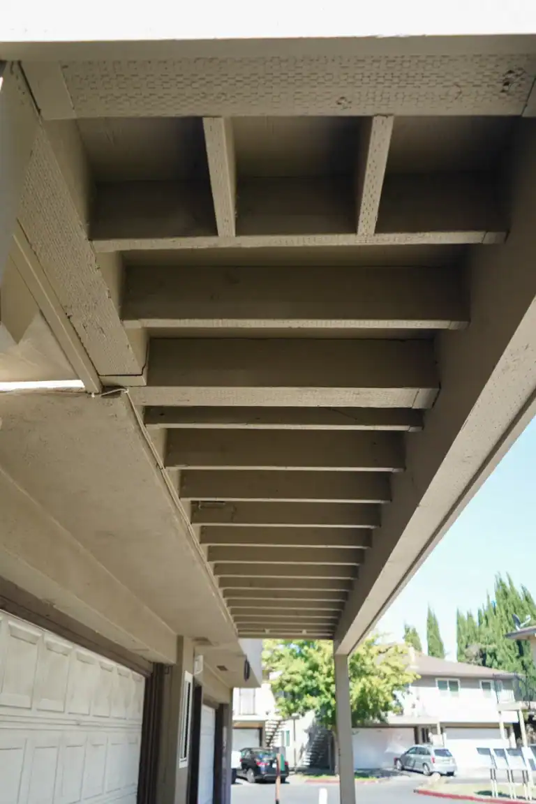 Repaired and repainted wood joists, beams, and fascia beneath a commercial deck