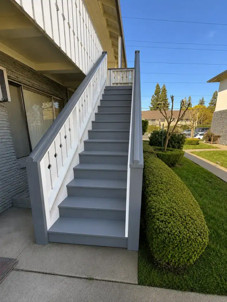 Rebuilt exterior apartment stairway in Sacramento with new non-slip coating on the treads and repainted wood balustrade