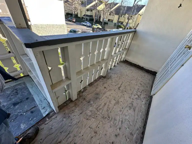 Second-floor apartment balcony torn off to the sheathing during a multifamily waterproofing project