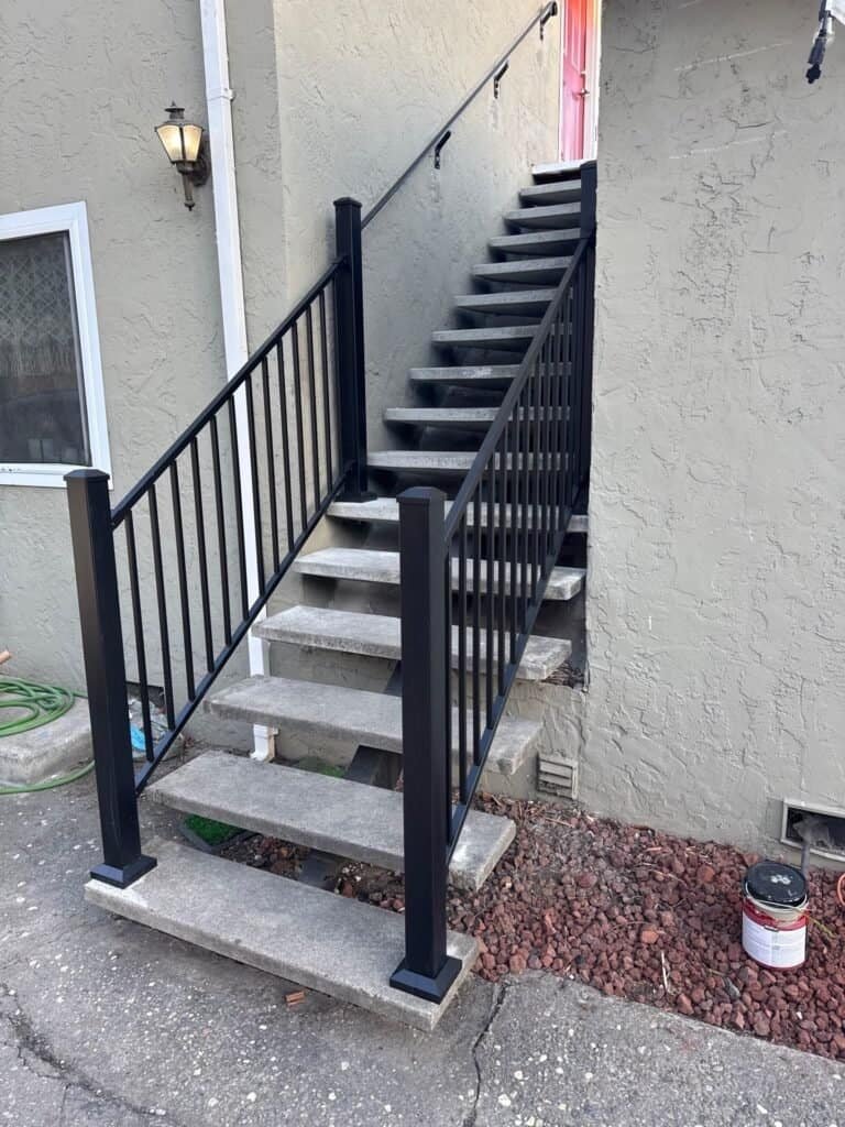 Exterior apartment stair in San Jose with new aluminum guards and a wall-mounted graspable handrail