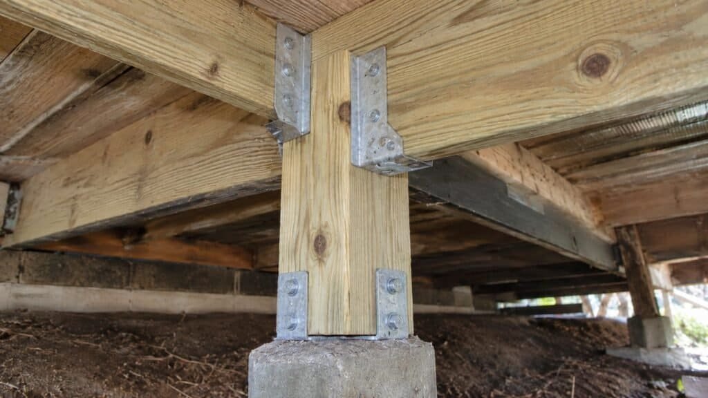 Restored connection with new pressure-treated post and corrosion-resistant galvanized brackets under a coastal deck