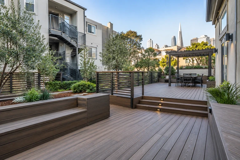 Deck contractors San Francisco — rebuilt rear deck and stair beside an older building with an exterior fire stair