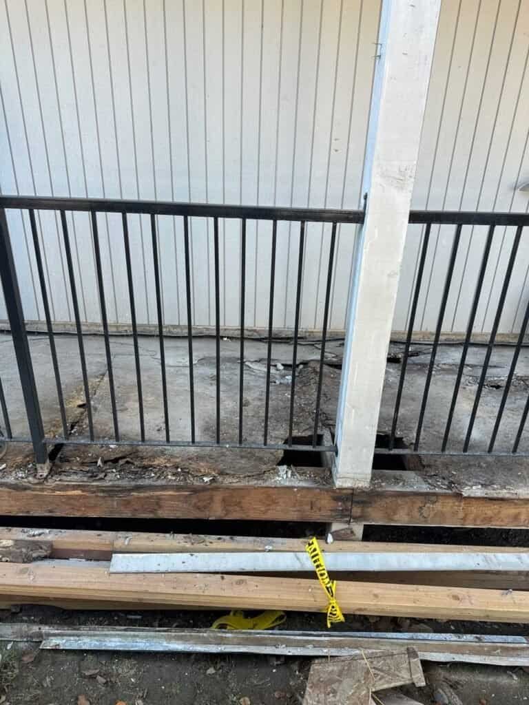 Cracked and delaminating deck coating over a rotted rim joist at a Rio Linda apartment walkway before repair