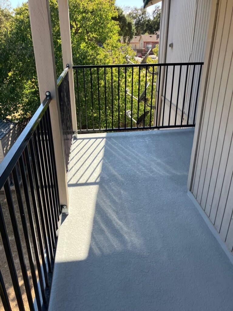 Private apartment balcony in Rio Linda with a new waterproof deck coating and black guardrail