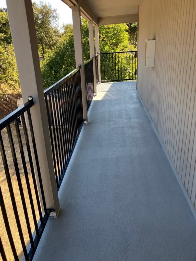 Rio Linda apartment walkway finished with a grey textured waterproof deck coating