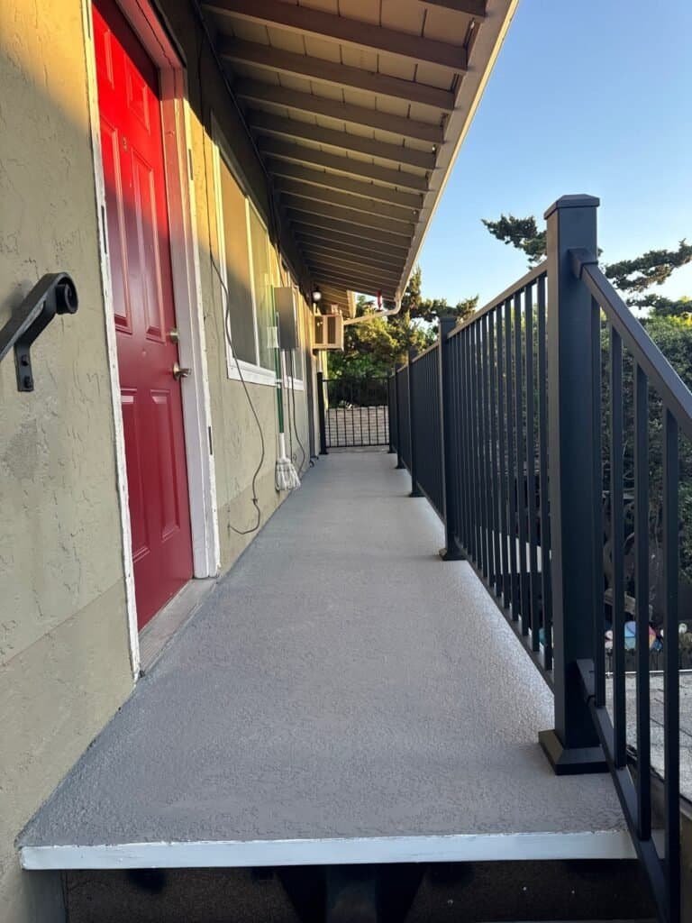 San Jose apartment walkway finished with a textured waterproof surface and black aluminum guardrail