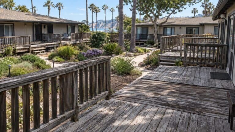 Weathered private patio decks across a bungalow courtyard community in San Rafael before replacement