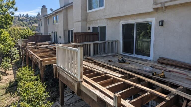 Row of townhome decks mid-rebuild across a hillside community in San Ramon with framing exposed and lumber staged