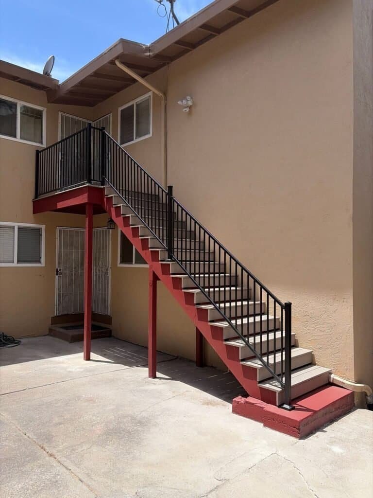 Oakland apartment building with composite stair treads, rebuilt landing and black aluminum guardrails