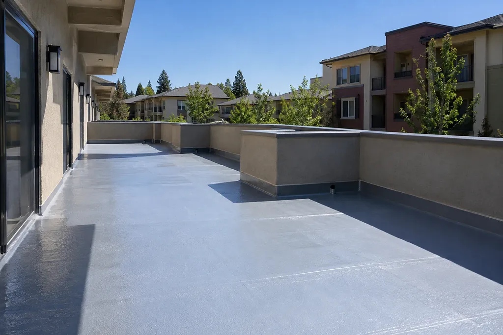 Waterproofing Sacramento CA — coated elevated walkway with coved wall base at an apartment community