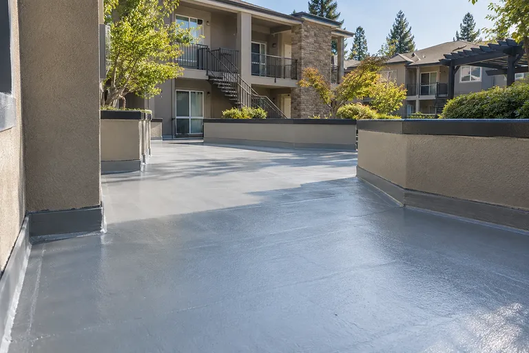 Waterproofing Sacramento — coated exterior walkway and landings at a garden-style apartment community