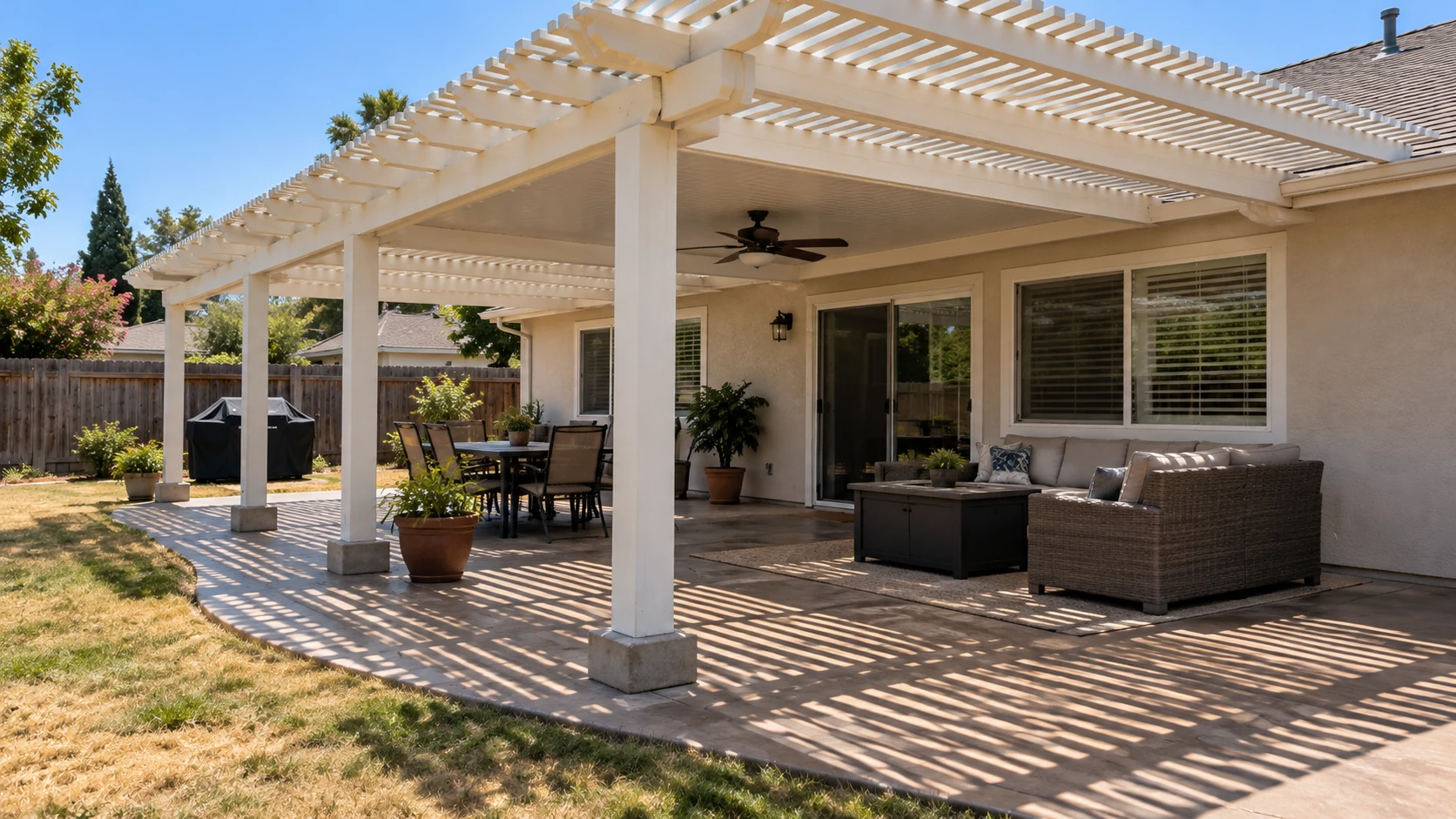 Backyard patio under a white pergola with outdoor furniture