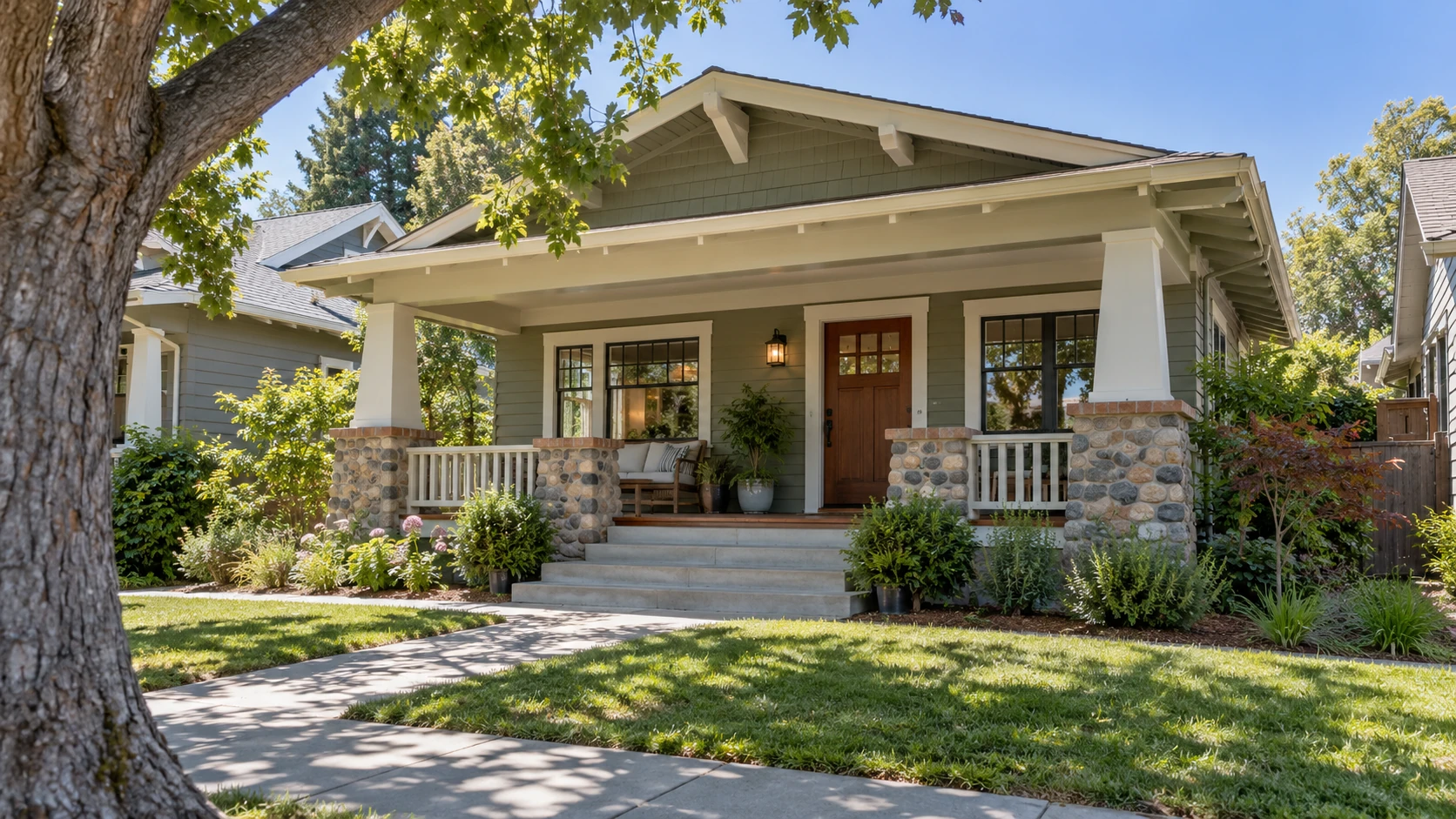 Craftsman house with a covered front porch, stone column bases, and steps