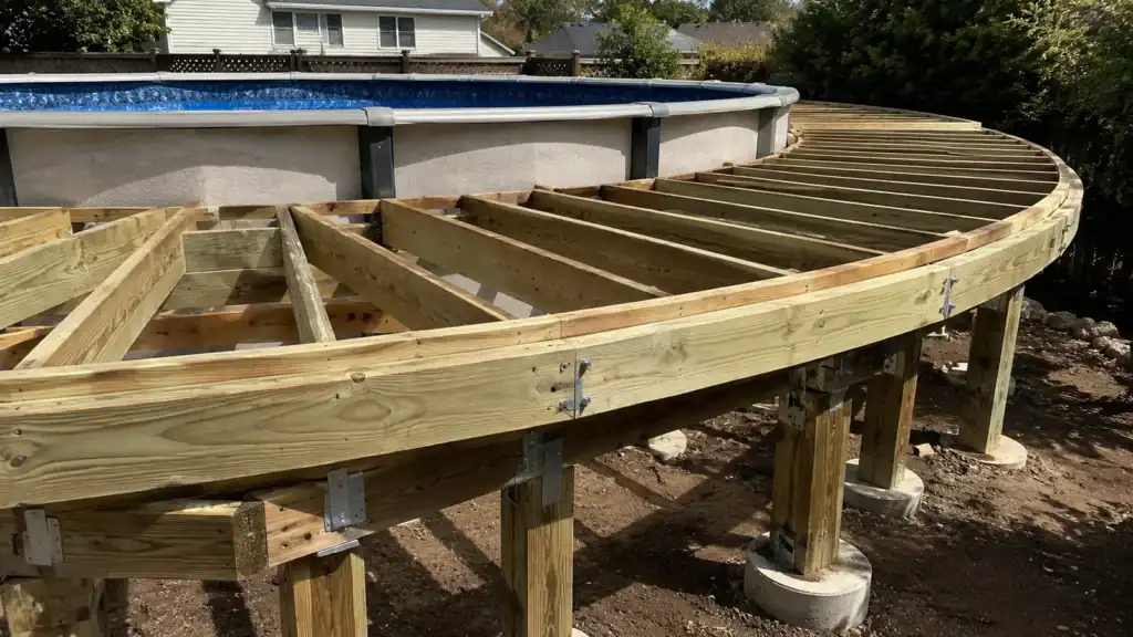 Freestanding deck frame on its own posts and footings, standing clear of an above-ground pool wall