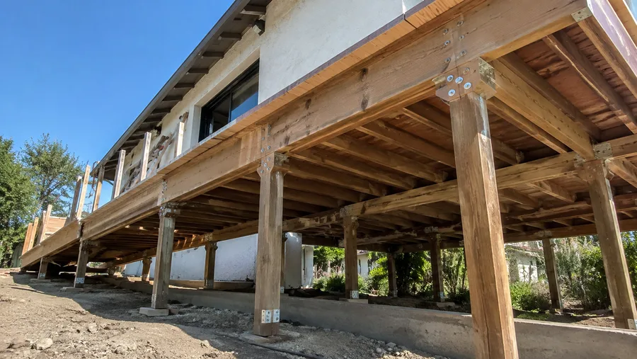 Accessible deck structure under construction, framed on posts with a long ramp run