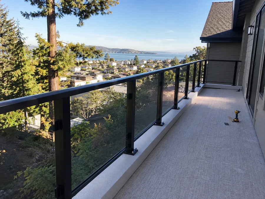 Glass panel balcony railing installed along a long elevated balcony run