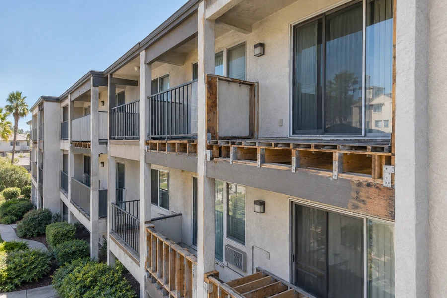 Apartment elevation with balcony framing exposed and the original members visible at the wall