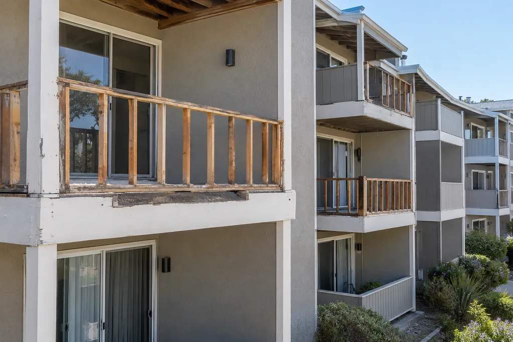 Solid balcony railing panels stripped back to the frame, with untouched solid-panel balconies alongside