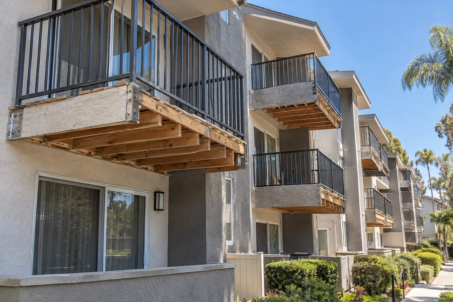 Balcony frames exposed mid-remodel with new guardrails fitted above