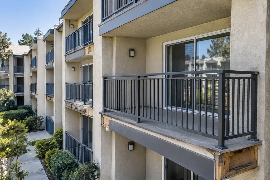Renovated balcony with new railing and surface sitting on the original timber rim, untouched balconies alongside