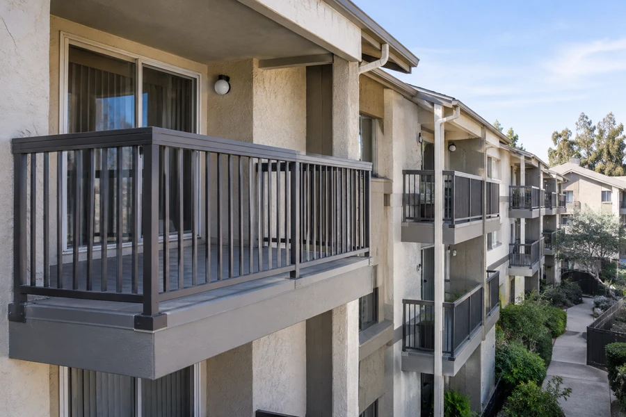 Renovated balcony with new surface and guardrail, seen along a courtyard elevation