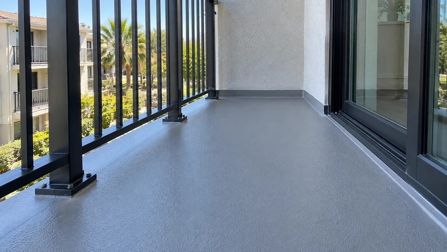 Restored balcony with a new textured coating turned up at the wall and rail posts reset on base plates