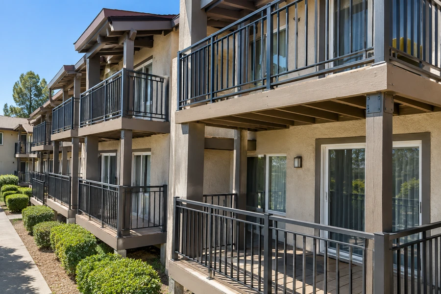 Stacked balconies with restored timber framing and refinished guardrails across an elevation