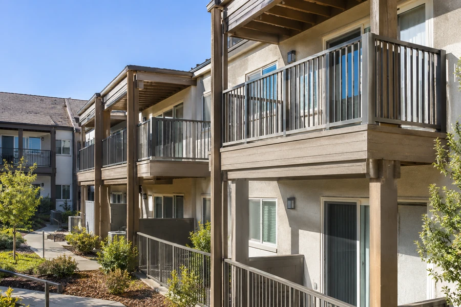 Restored balconies on a three-storey building with new guardrails and refinished fascia