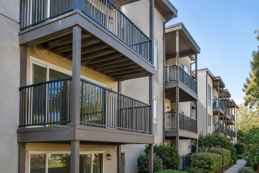 Apartment elevation after balcony restoration, with repainted framing and metal guardrails throughout