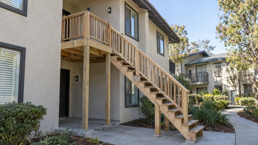 New outdoor balcony stairs with stringers, posts on concrete pads and matching guardrails