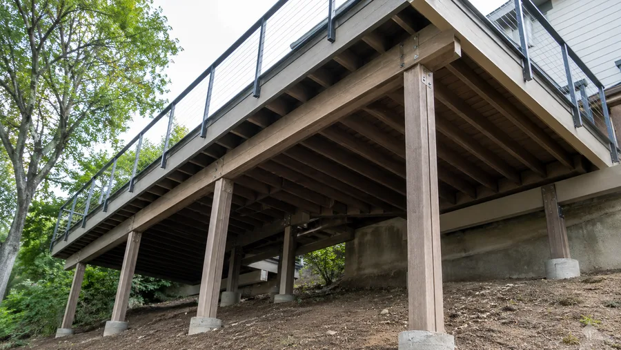 Composite deck seen from below, showing the wood post-and-beam structure carrying it