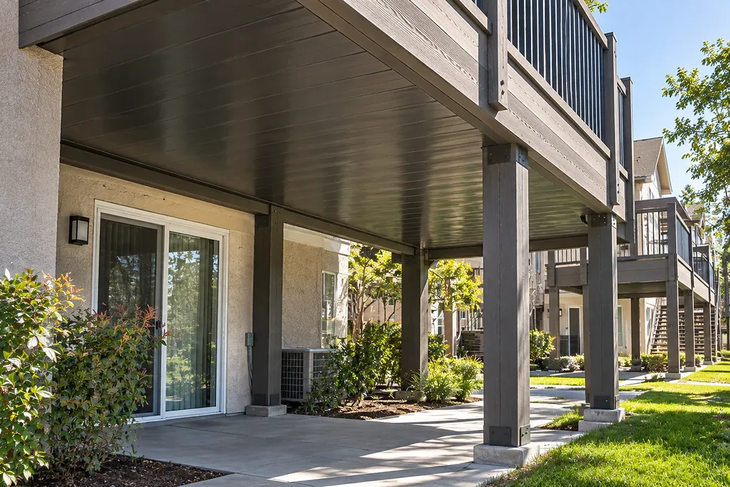 Composite deck on timber posts with the underside enclosed, keeping the patio below dry