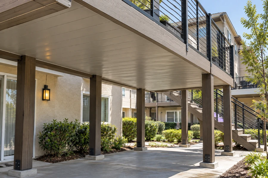 Composite decks with cable railings above an enclosed ground-floor walkway
