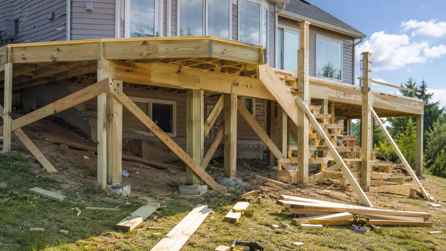 Deck structure with knee-braced posts, framed stairs and beams on concrete piers