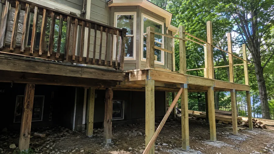 New framing built alongside an older deck, tied in at the existing structure
