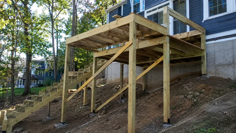 Full deck structure with posts on piers, diagonal bracing, beams and a framed stair run
