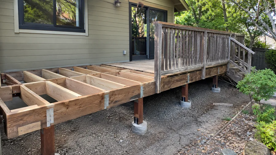Deck rebuild underway, new framing on new piers beside the old deck and railings
